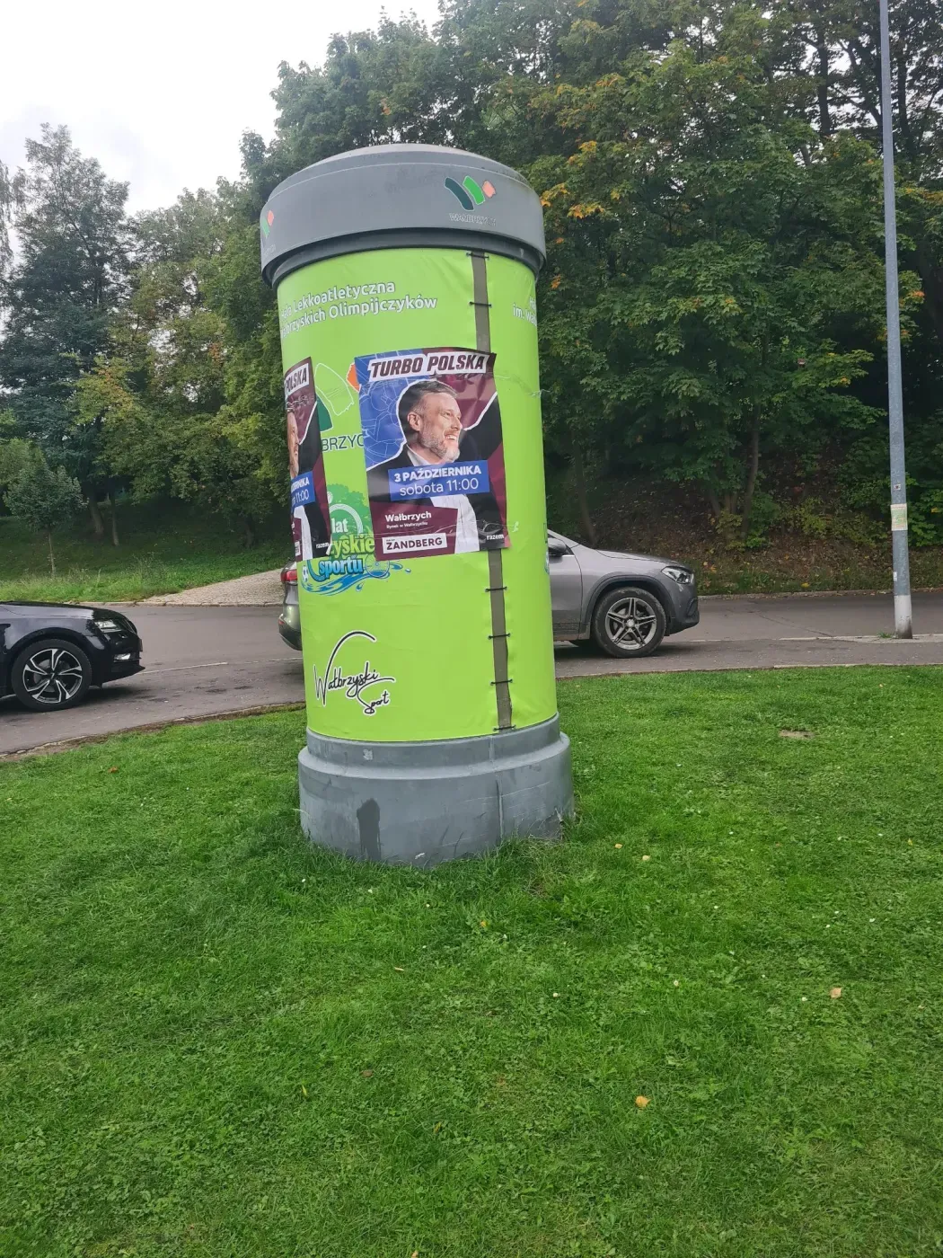 Słup ogłoszeniowy z plakatem Turbo Polska na zielonym tle w Wałbrzychu